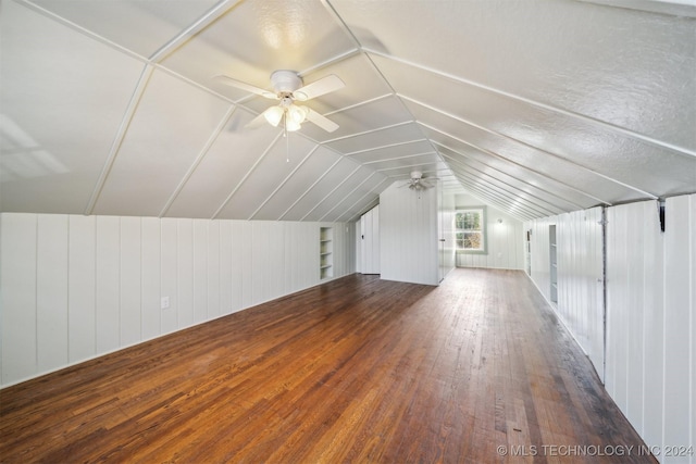 bonus room featuring a textured ceiling, ceiling fan, lofted ceiling, and dark wood-type flooring