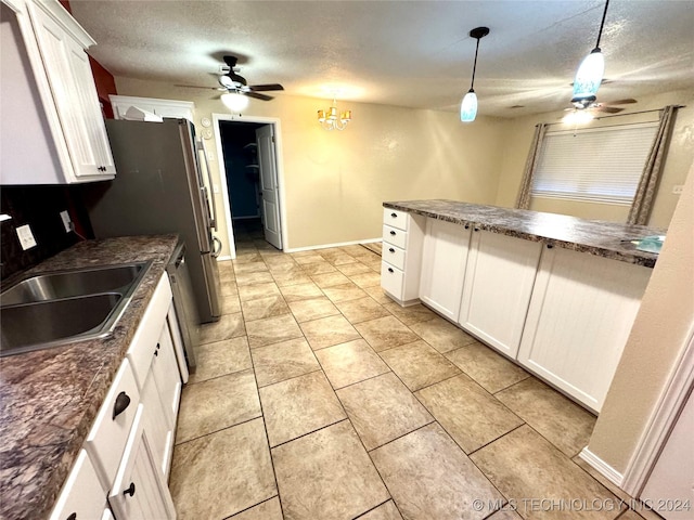 kitchen featuring ceiling fan with notable chandelier, a textured ceiling, sink, white cabinetry, and hanging light fixtures