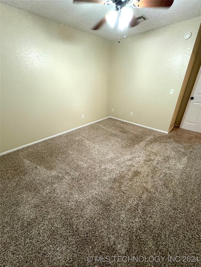 carpeted spare room with a textured ceiling