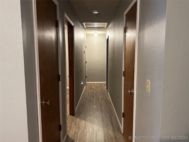 hall featuring hardwood / wood-style floors and a textured ceiling