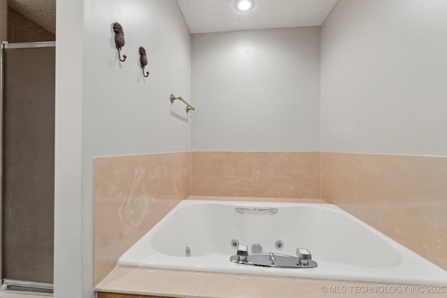 bathroom featuring a shower with door, a textured ceiling, and a whirlpool tub