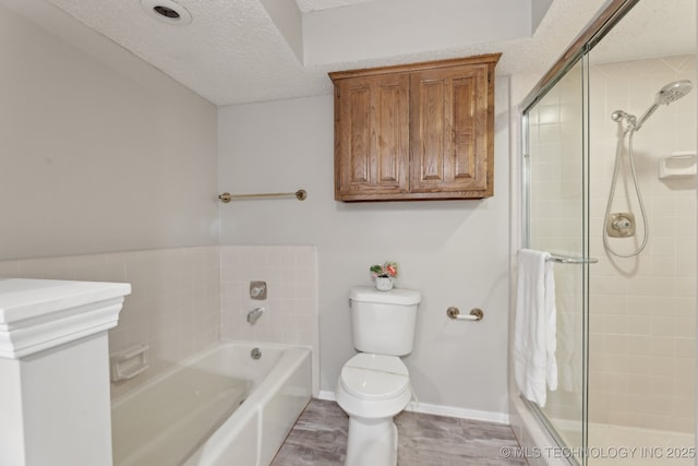 bathroom with a bathing tub, toilet, and a textured ceiling