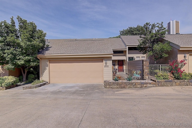 view of front facade featuring concrete driveway and roof with shingles