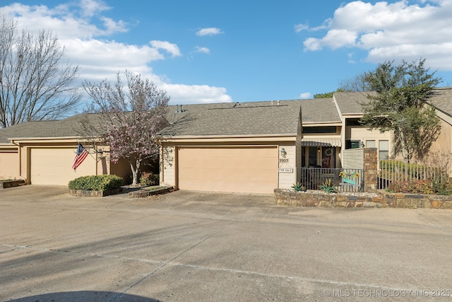 view of front of house featuring a garage, driveway, and roof with shingles