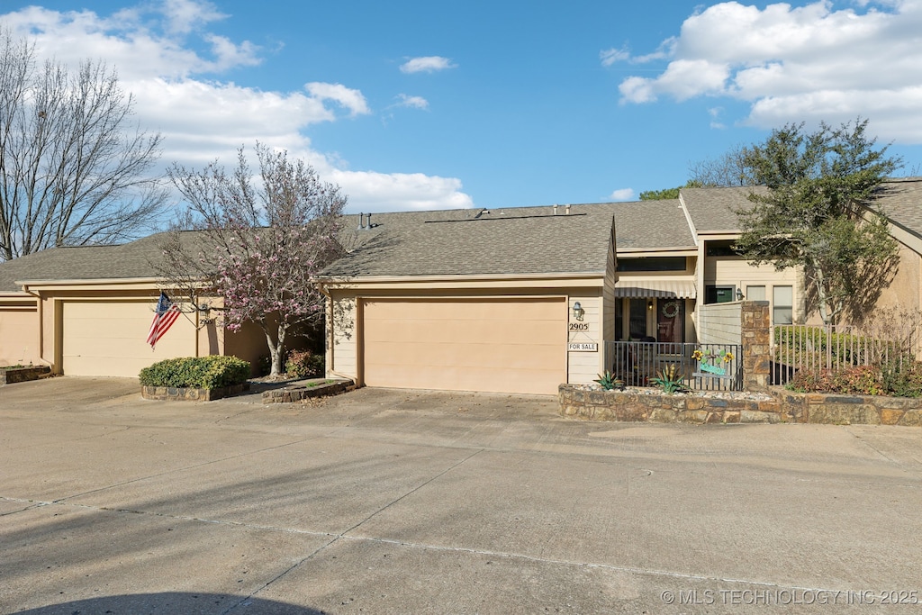 2905 E 85th St Unit 89, Tulsa, OK 74137 - view of front facade featuring a garage, driveway, and roof with shingles
