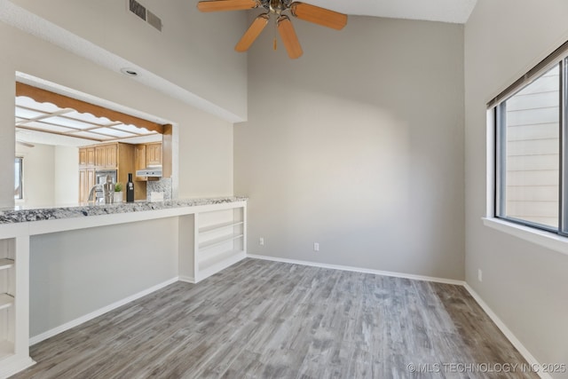 interior space featuring light wood finished floors, visible vents, ceiling fan, and baseboards