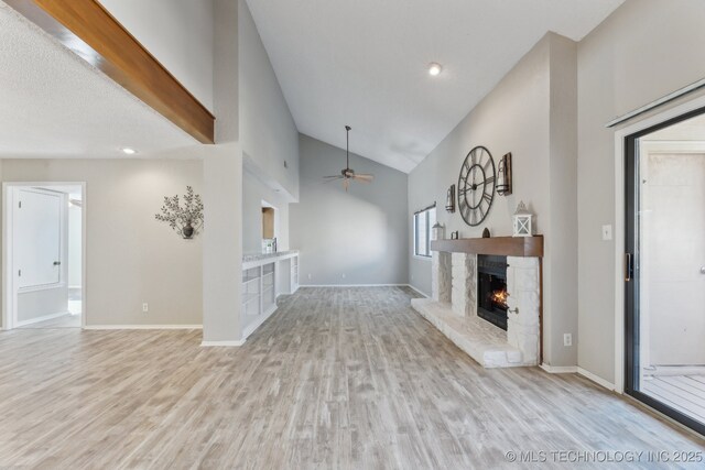 unfurnished living room with a ceiling fan, wood finished floors, a fireplace, and baseboards