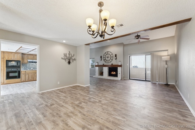 unfurnished living room featuring light wood finished floors, visible vents, a fireplace, and baseboards