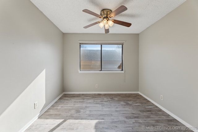 spare room with wood finished floors, a ceiling fan, baseboards, and a textured ceiling