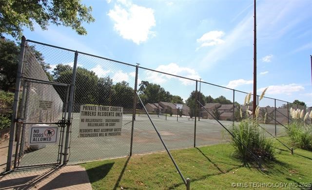 view of sport court with fence and a gate