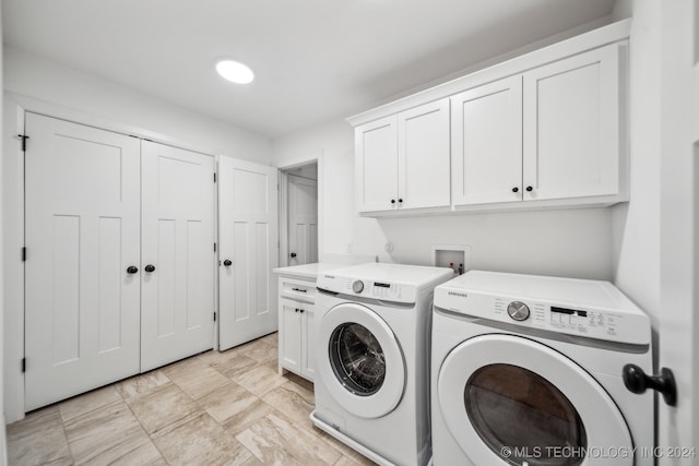 laundry area with separate washer and dryer and cabinets