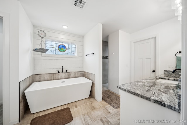 bathroom featuring vanity and independent shower and bath