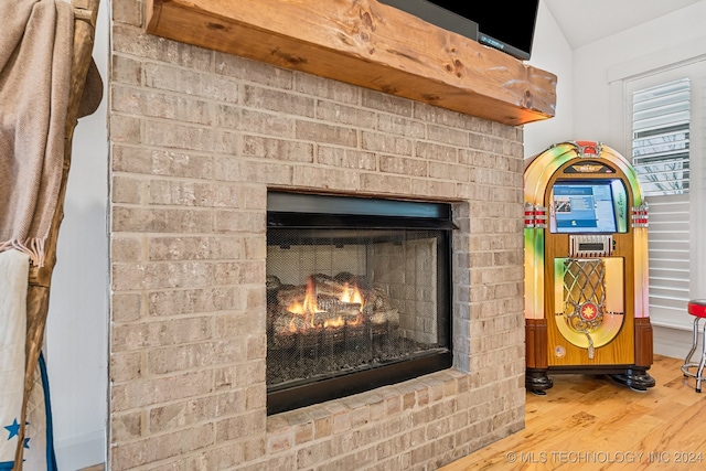 interior details featuring hardwood / wood-style flooring and a brick fireplace