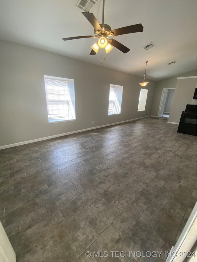 unfurnished living room featuring ceiling fan, a healthy amount of sunlight, and vaulted ceiling