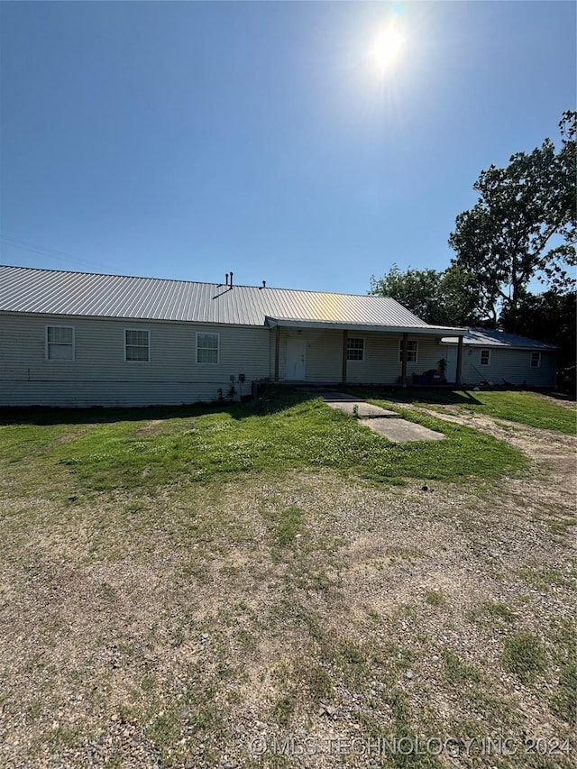 rear view of property with a yard