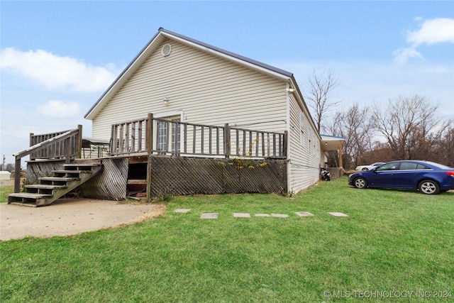 back of property with a lawn and a deck