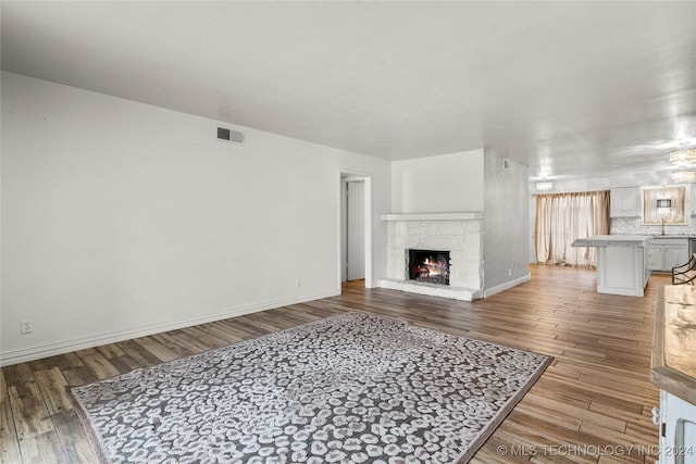 living room with hardwood / wood-style flooring, sink, and a fireplace