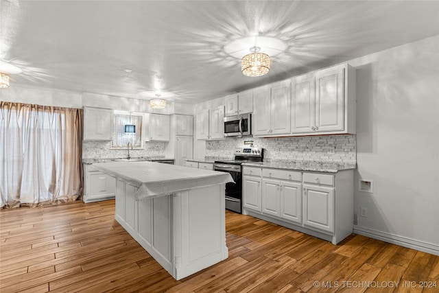 kitchen featuring white cabinets, appliances with stainless steel finishes, light hardwood / wood-style flooring, and sink