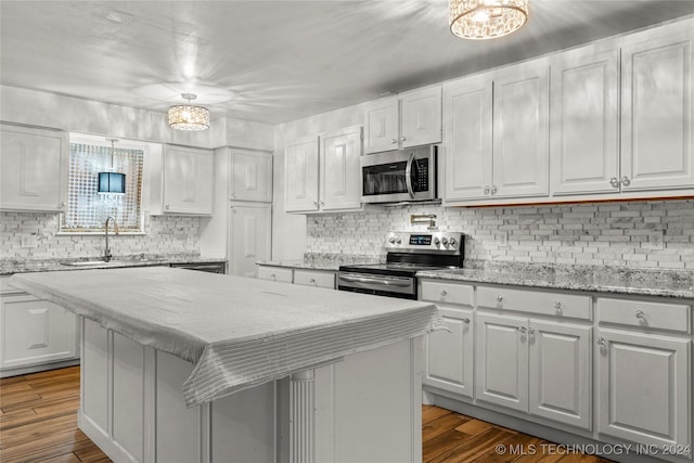 kitchen featuring white cabinetry, a center island, stainless steel appliances, and dark hardwood / wood-style floors