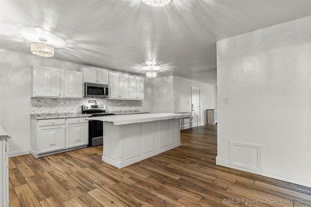 kitchen featuring white cabinets, appliances with stainless steel finishes, decorative backsplash, and light hardwood / wood-style flooring