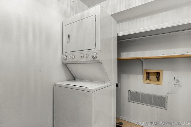 laundry room featuring stacked washer / drying machine