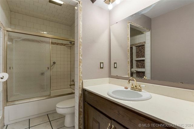 full bathroom featuring tile patterned flooring, vanity, toilet, and bath / shower combo with glass door