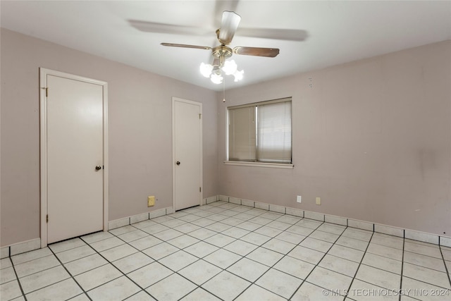 tiled spare room with ceiling fan