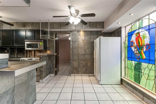 kitchen featuring appliances with stainless steel finishes, tile walls, and light tile patterned flooring