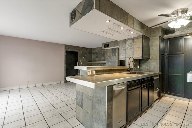 kitchen with ceiling fan, sink, kitchen peninsula, light tile patterned flooring, and tile walls