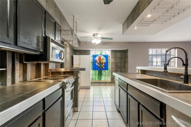 kitchen featuring appliances with stainless steel finishes, backsplash, ceiling fan, sink, and light tile patterned floors