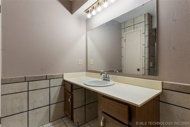 bathroom featuring tile patterned flooring, vanity, and tile walls