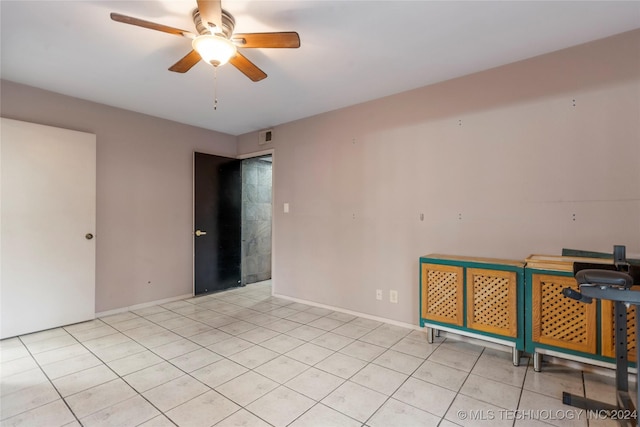 empty room with ceiling fan and light tile patterned floors