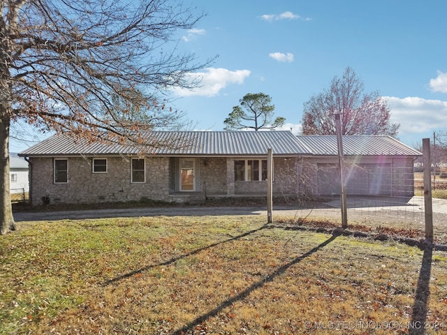 back of house featuring a lawn and a garage