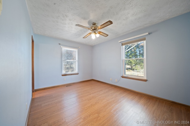 unfurnished room with ceiling fan, light hardwood / wood-style floors, and a textured ceiling