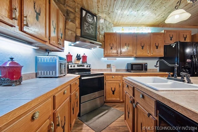 kitchen with wooden ceiling, black appliances, sink, range hood, and tile counters