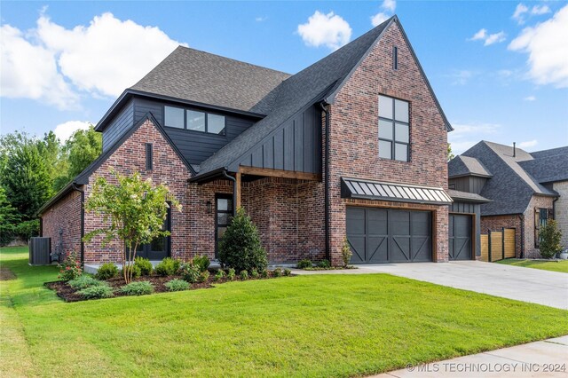 view of front of home with a garage, central air condition unit, and a front yard