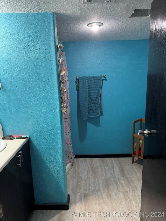 bathroom featuring vanity, wood-type flooring, a textured ceiling, and walk in shower