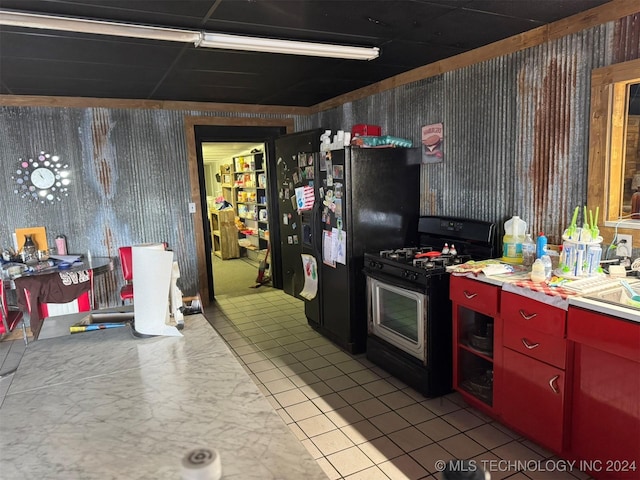 kitchen featuring light tile patterned flooring, sink, and black appliances