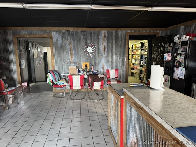 interior space with tile patterned floors and black refrigerator with ice dispenser