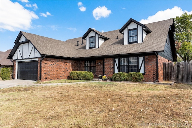 tudor home with a front yard and a garage