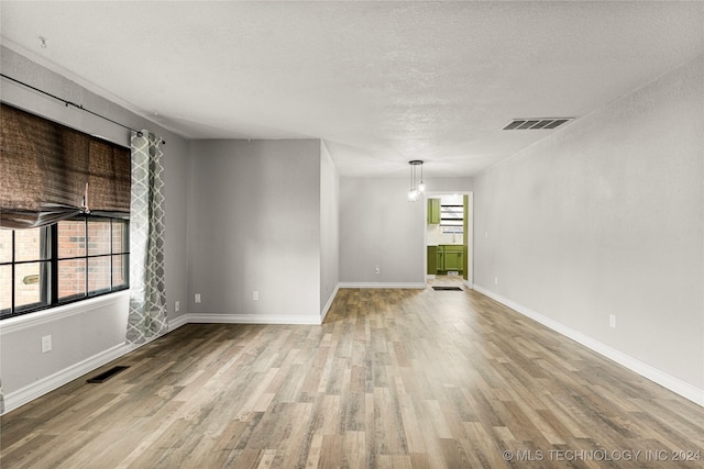 spare room featuring hardwood / wood-style flooring and a textured ceiling