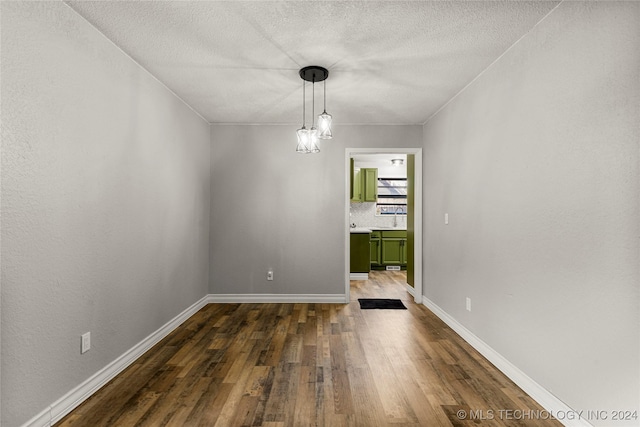 unfurnished dining area with a notable chandelier and dark hardwood / wood-style flooring