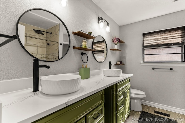 bathroom with a shower, vanity, wood-type flooring, and toilet