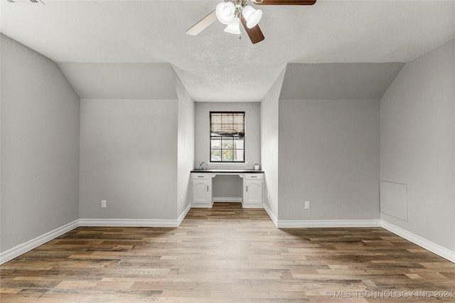 additional living space with light hardwood / wood-style floors, vaulted ceiling, and ceiling fan