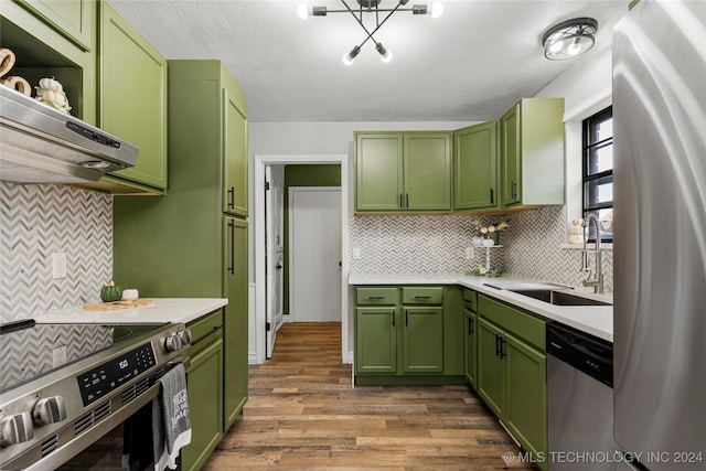 kitchen featuring wood-type flooring, sink, appliances with stainless steel finishes, and green cabinetry