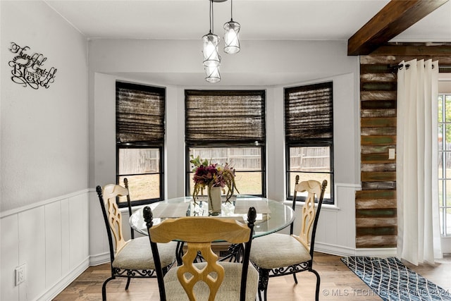 dining room with light hardwood / wood-style floors and beam ceiling