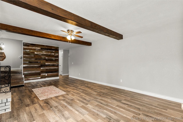 living room with hardwood / wood-style floors, ceiling fan, beam ceiling, and a textured ceiling