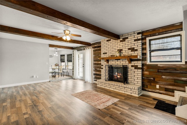 unfurnished living room with a fireplace, hardwood / wood-style floors, a textured ceiling, and wooden walls