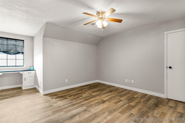 additional living space featuring hardwood / wood-style floors, a textured ceiling, ceiling fan, and lofted ceiling