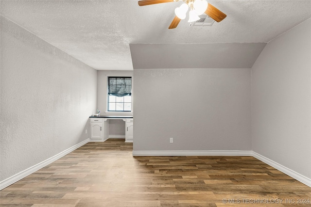 unfurnished room featuring a textured ceiling, ceiling fan, lofted ceiling, and hardwood / wood-style flooring